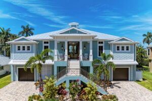 A blue home with palm trees and a driveway, perfect for those looking for a relaxing getaway.